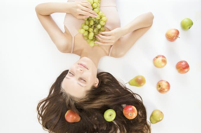 donna circondata da frutta
