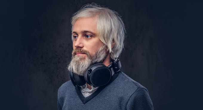 Uomo con capelli grigi e barba grigia, esempio di look naturale con capelli grigi
